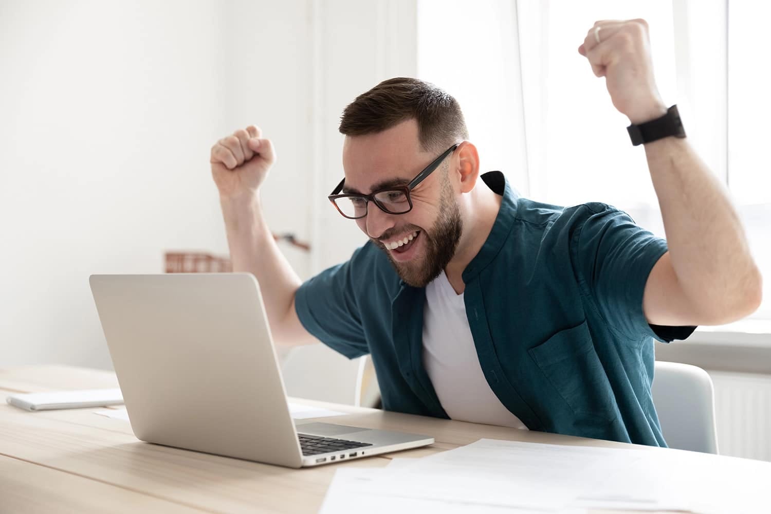 Overjoyed businessman wearing glasses looking at laptop screen in office Wakacyjny kurs